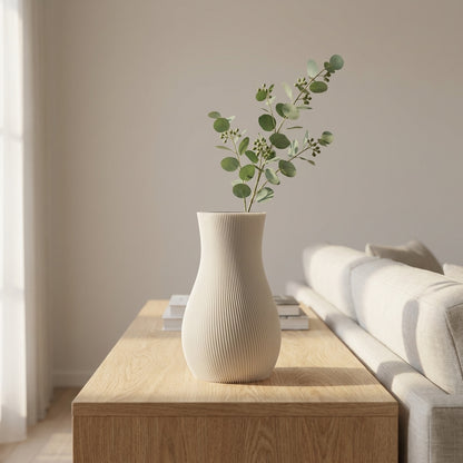 Hvid LUMA-vase med grønne grene i en lys stue