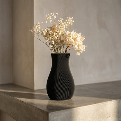 Sort LUMA-vase med lyse tørrede blomster i sollys
